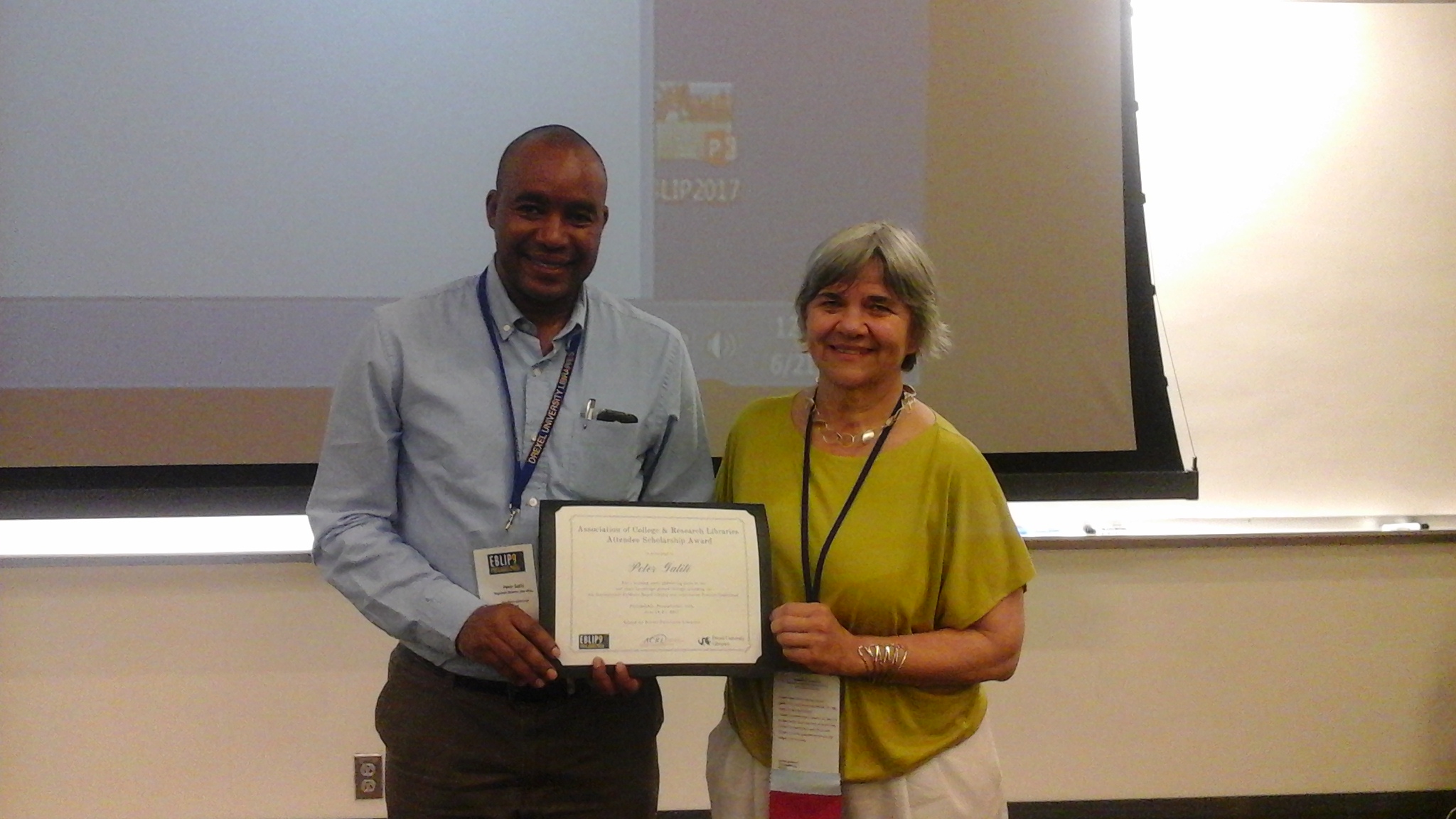 Peter Gatit holds his conference award with Danuta Nitecki standing next to him